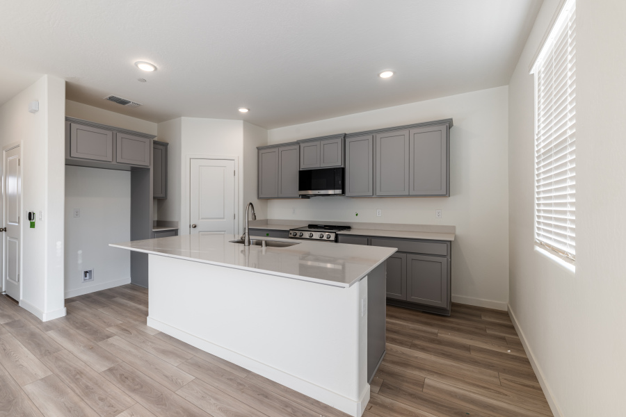 A kitchen with white cabinets.