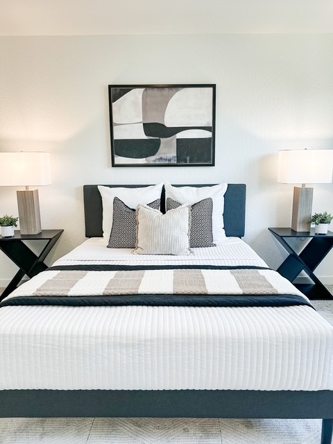 A bed with a white and black striped comforter.