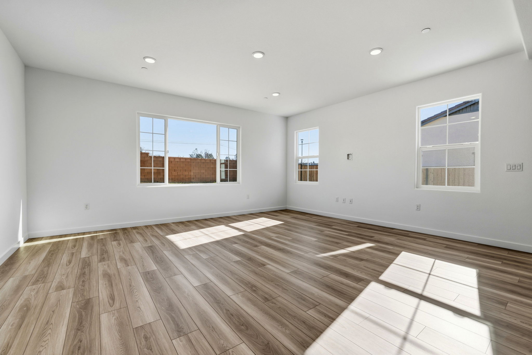 A room with a wood floor and windows.