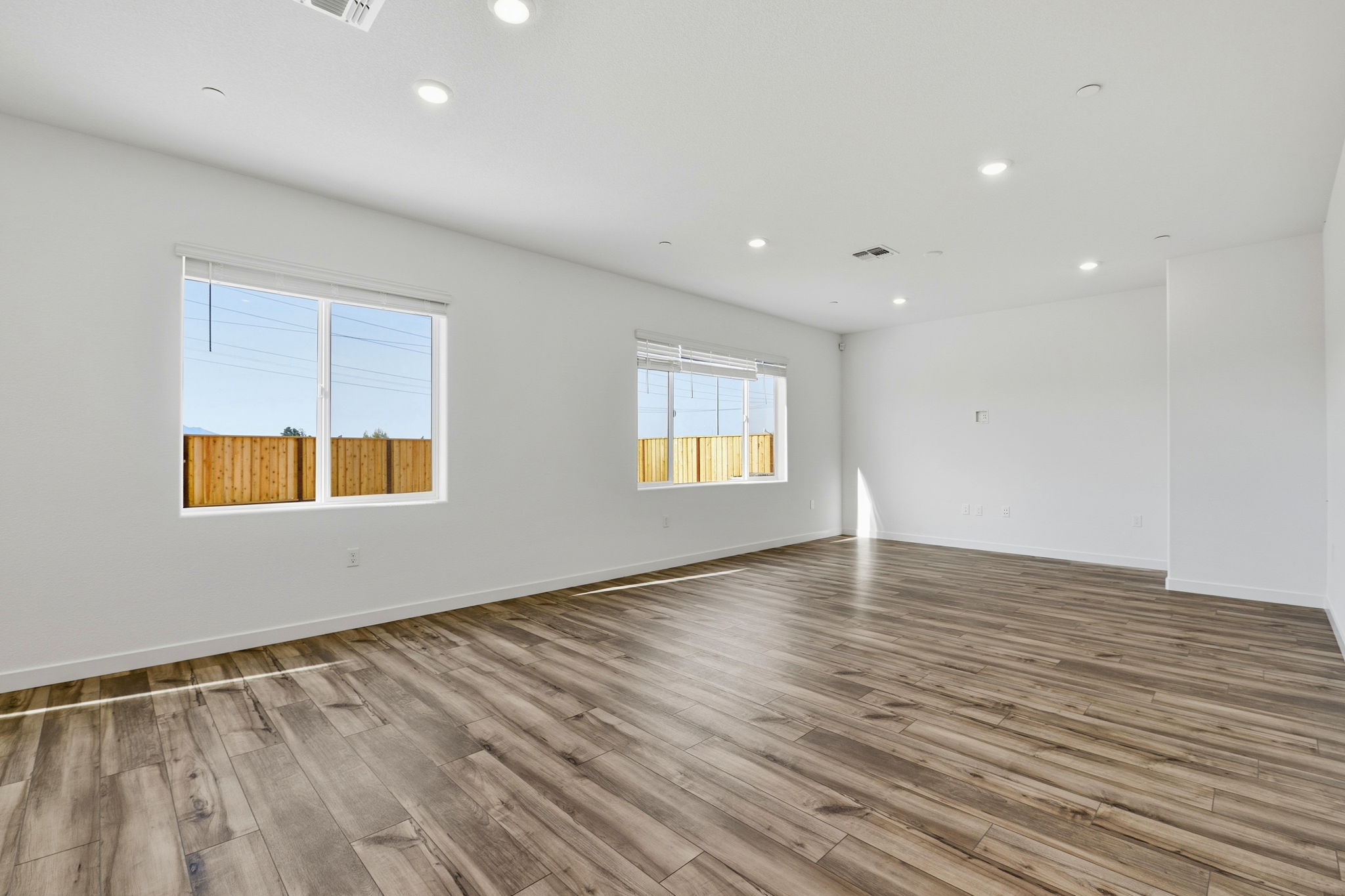 A room with a wood floor and windows.