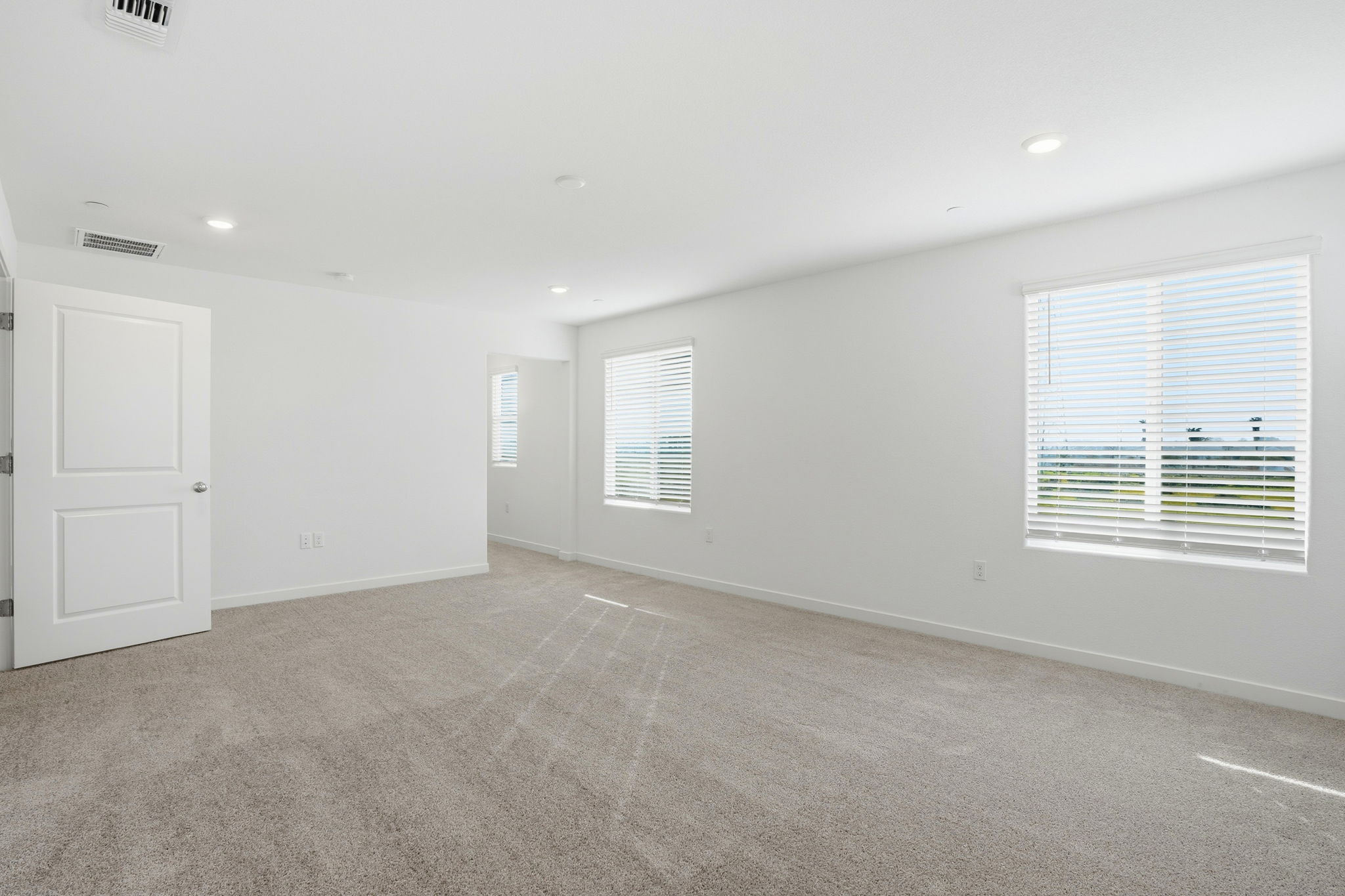A room with white walls and a carpet.