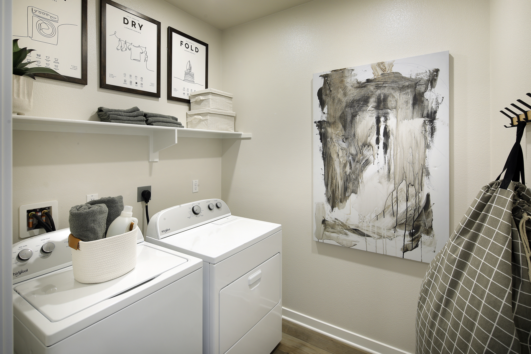 A room with a shelf and a sink with a picture on it.