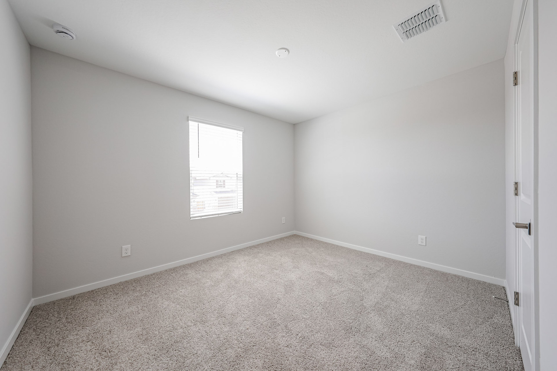 A room with a carpet and a door.