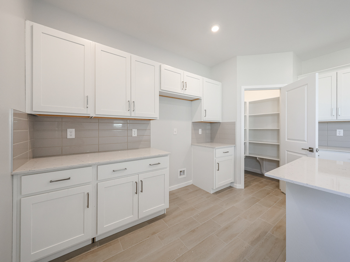 A kitchen with white cabinets.