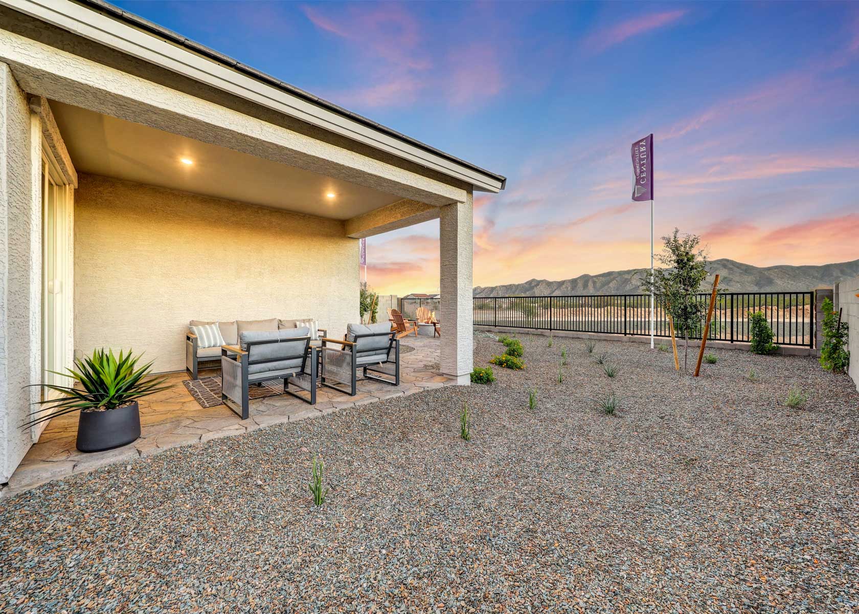 A building with a bench and a fence and a flag.