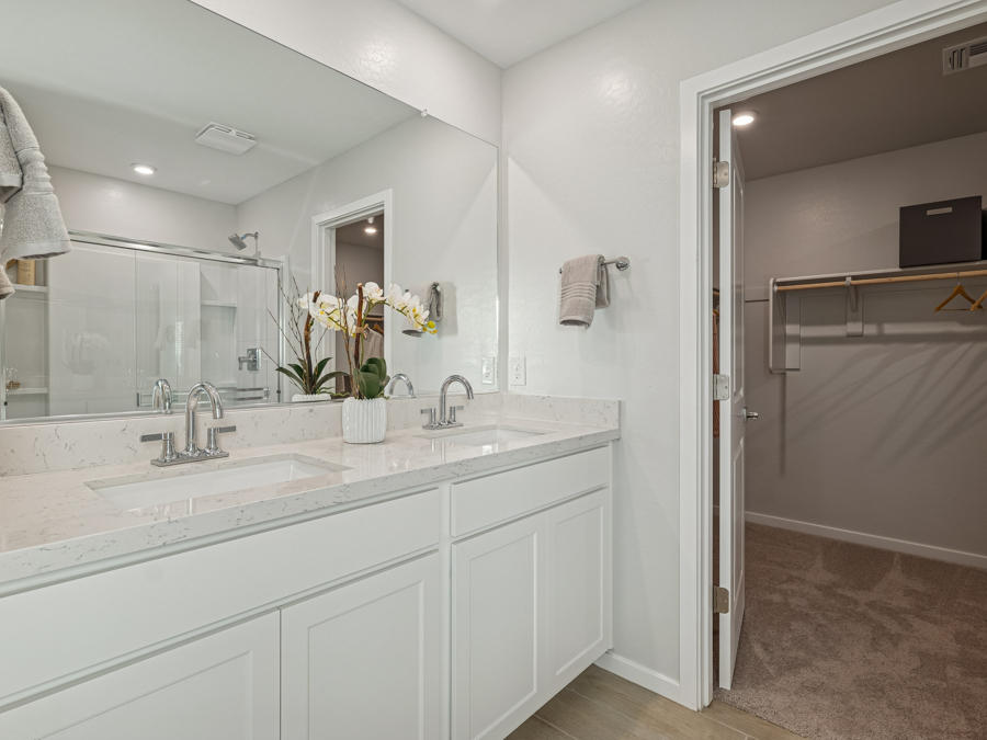 A bathroom with a sink and a shower unit.