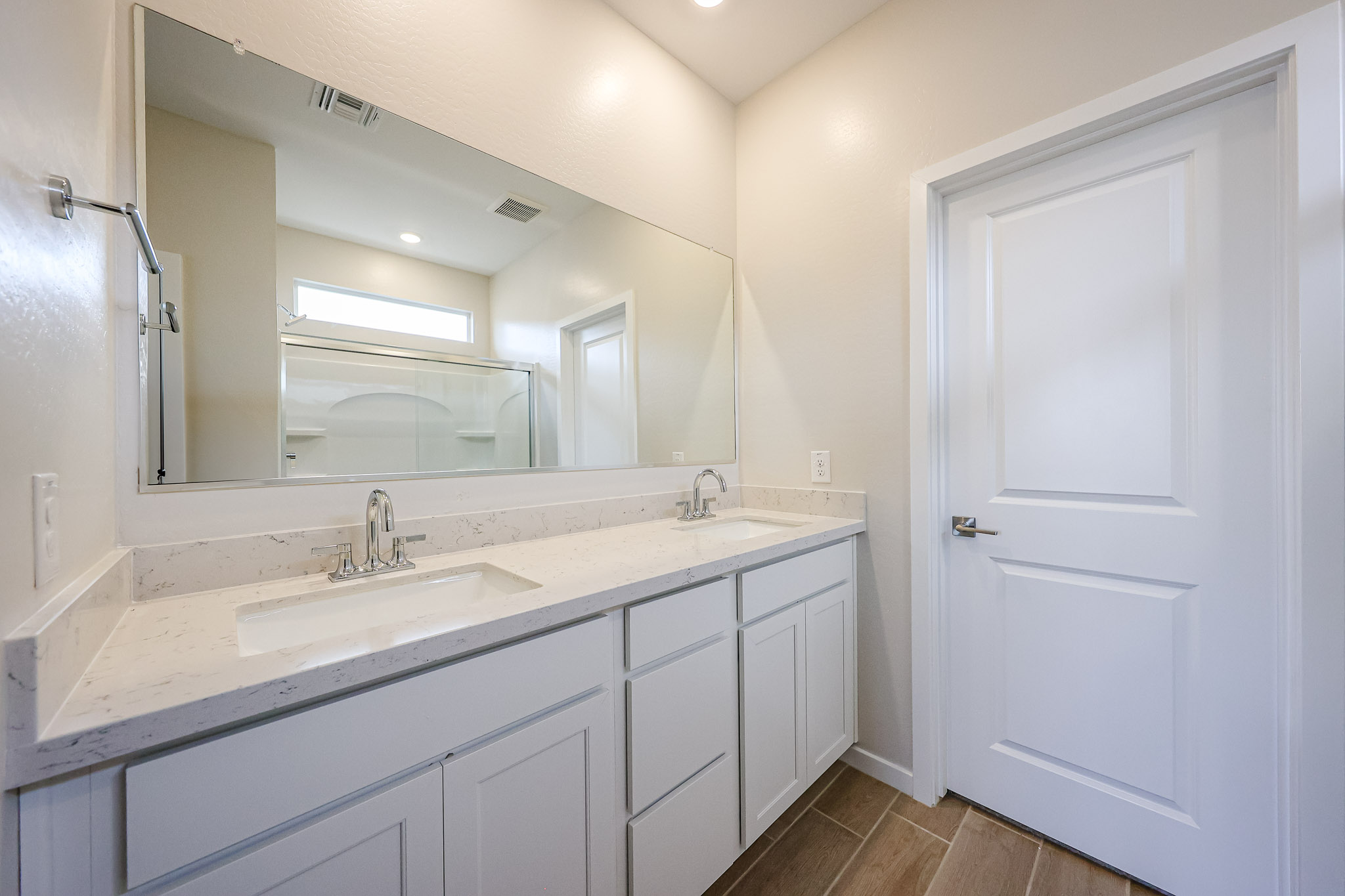 A bathroom with white cabinets.