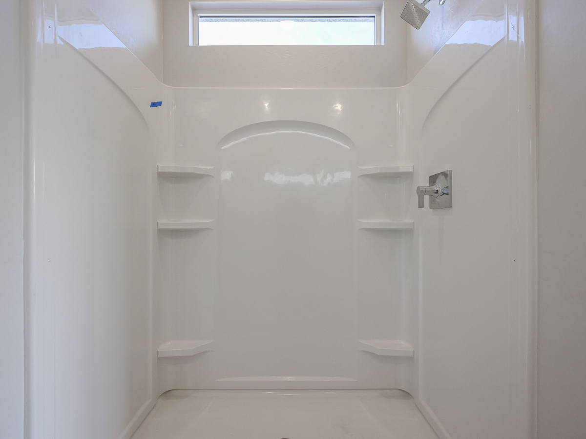A bathroom with a bathtub and shelves.
