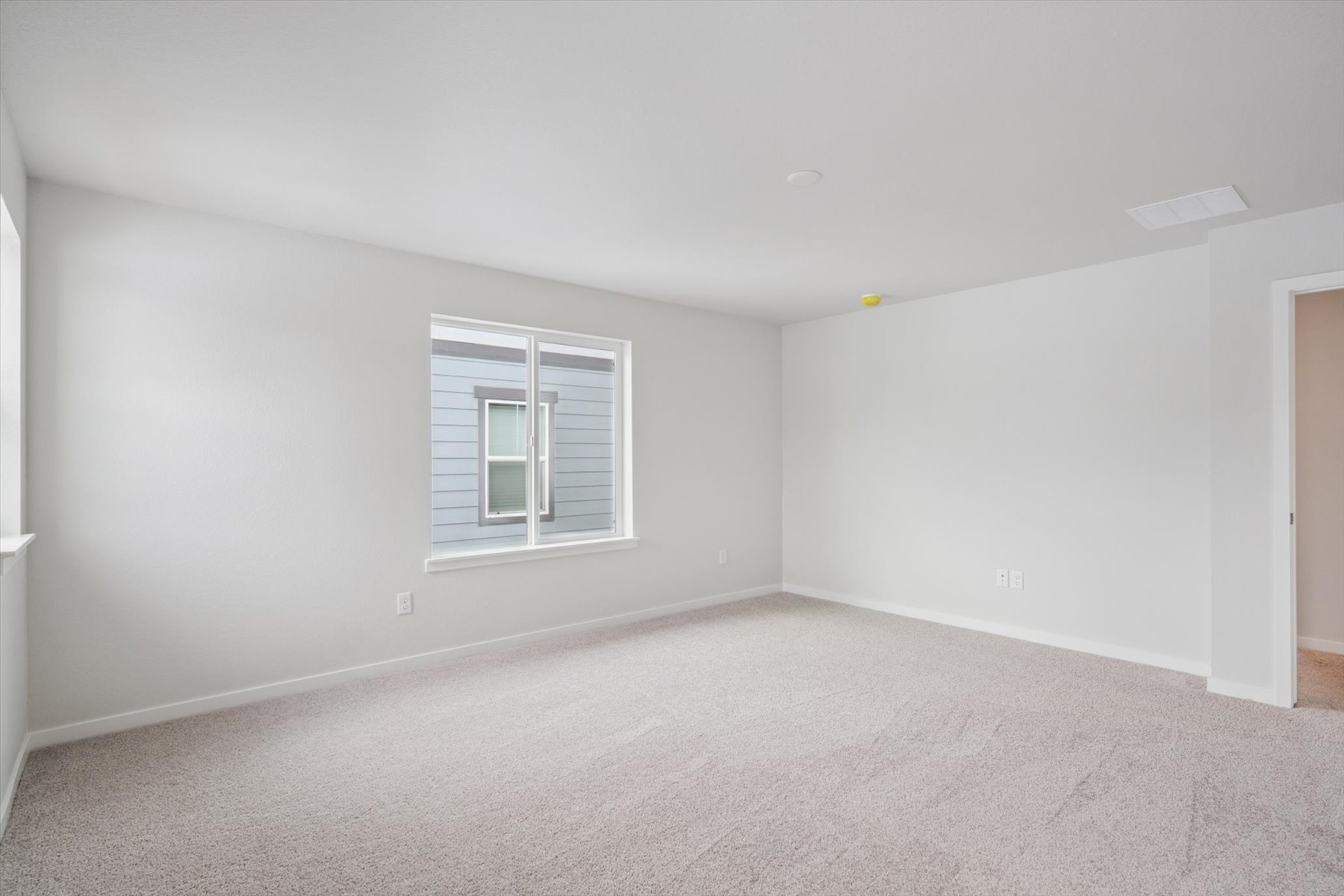 A room with a window and a carpet.