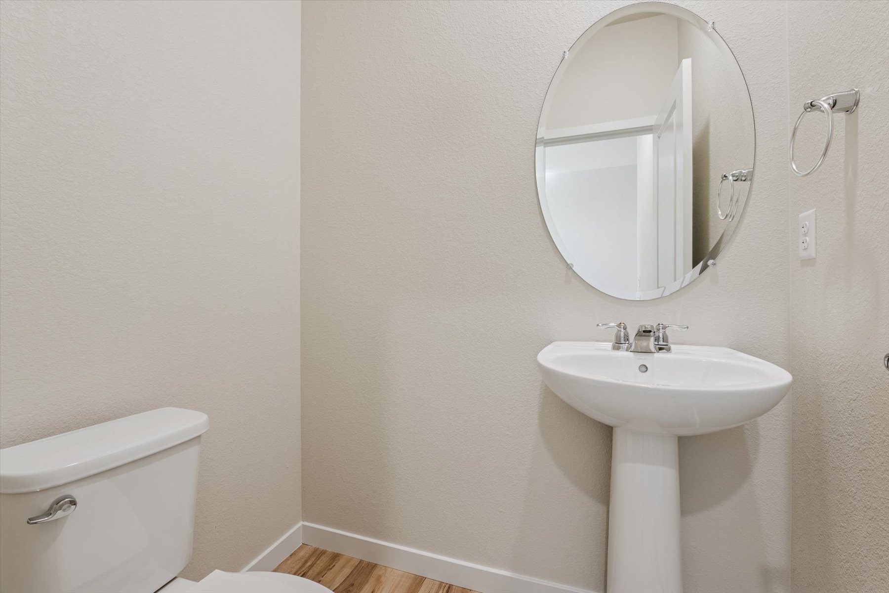 A bathroom with a round mirror.