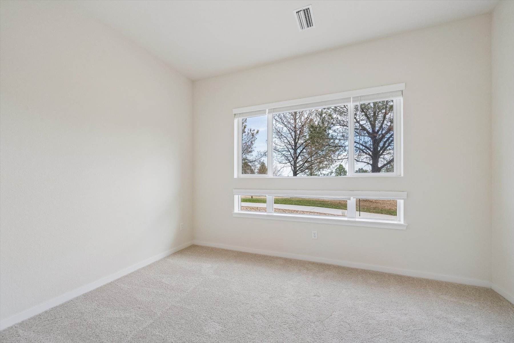 A room with a window and a carpet.