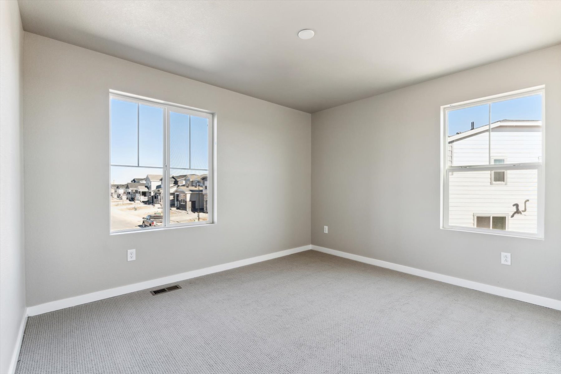A room with a window and a white wall.