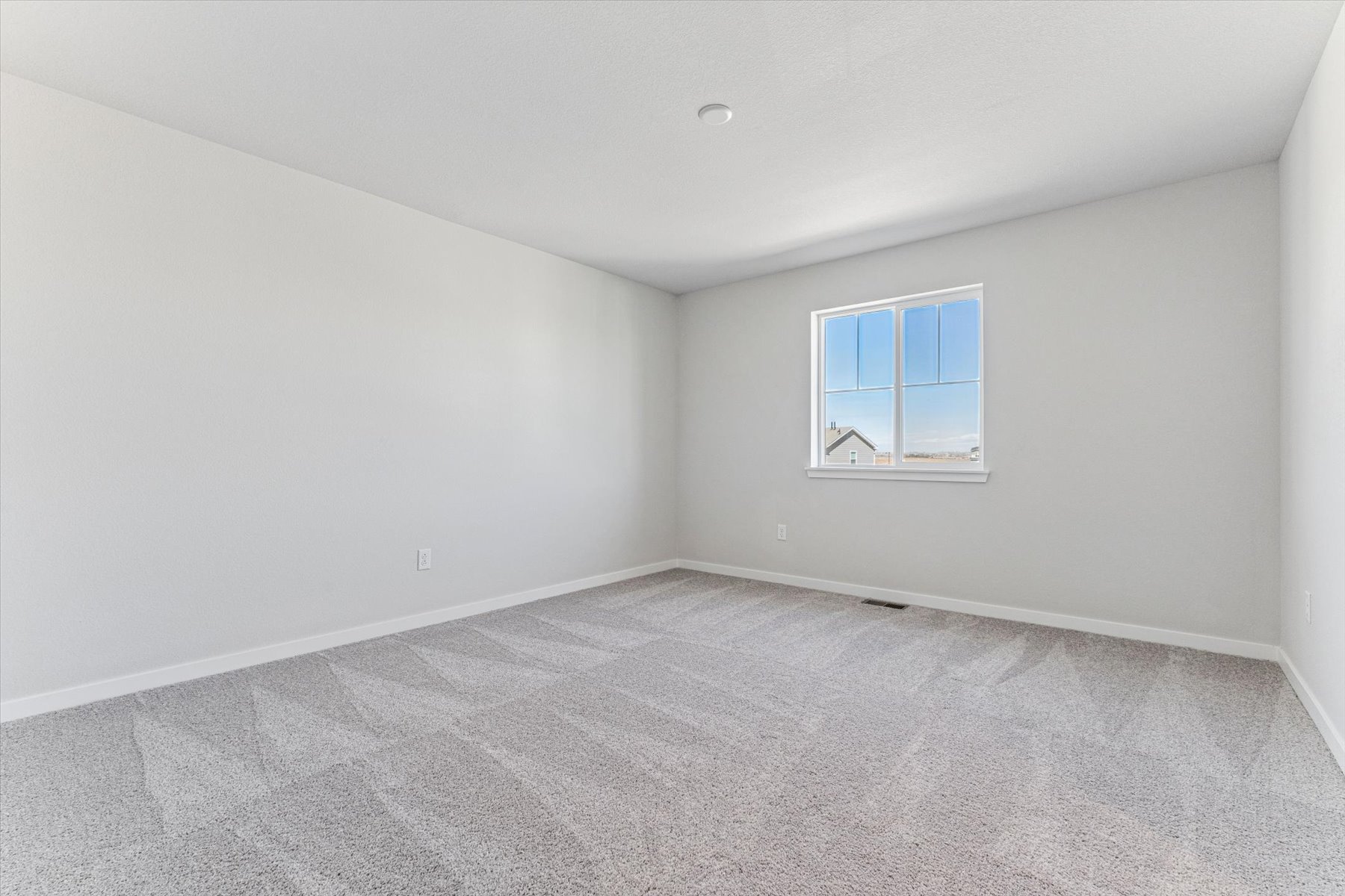 A room with a window and a carpet.