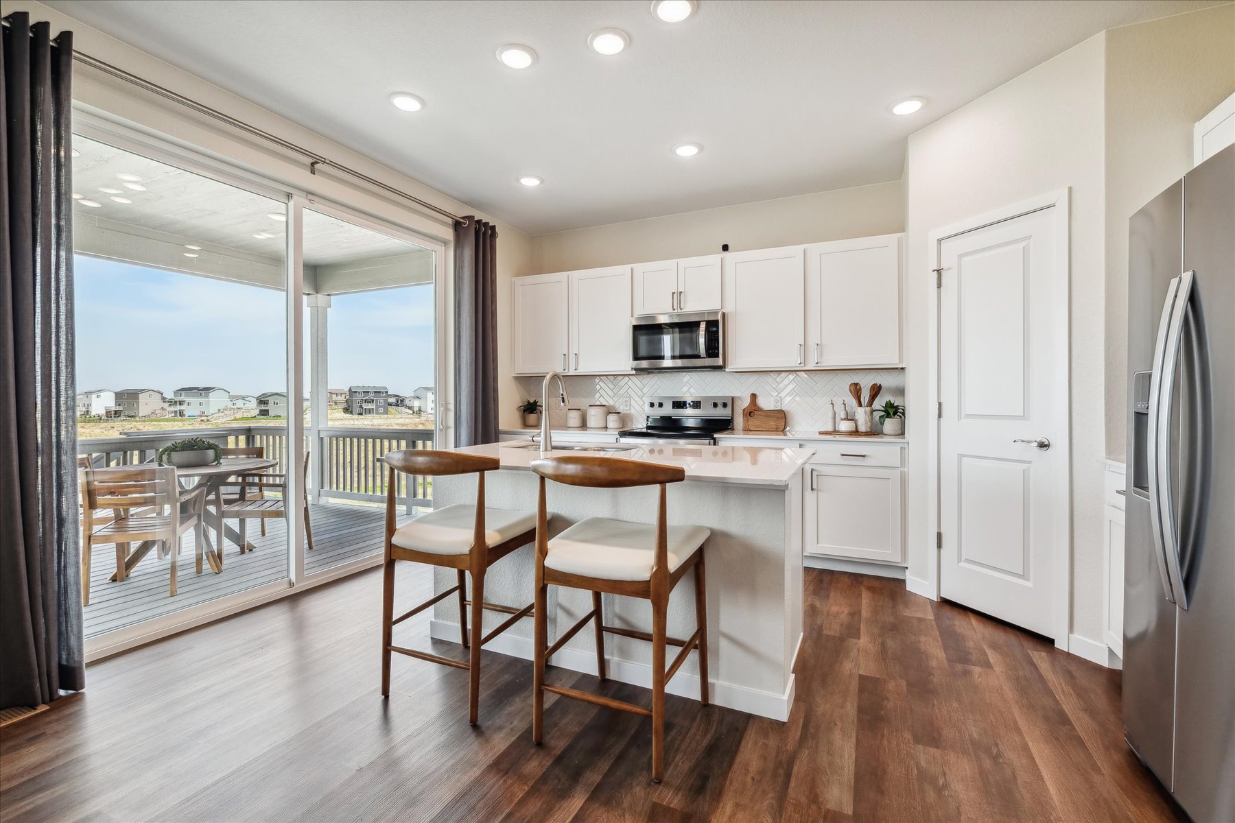 A kitchen with a table chairs and a large window.