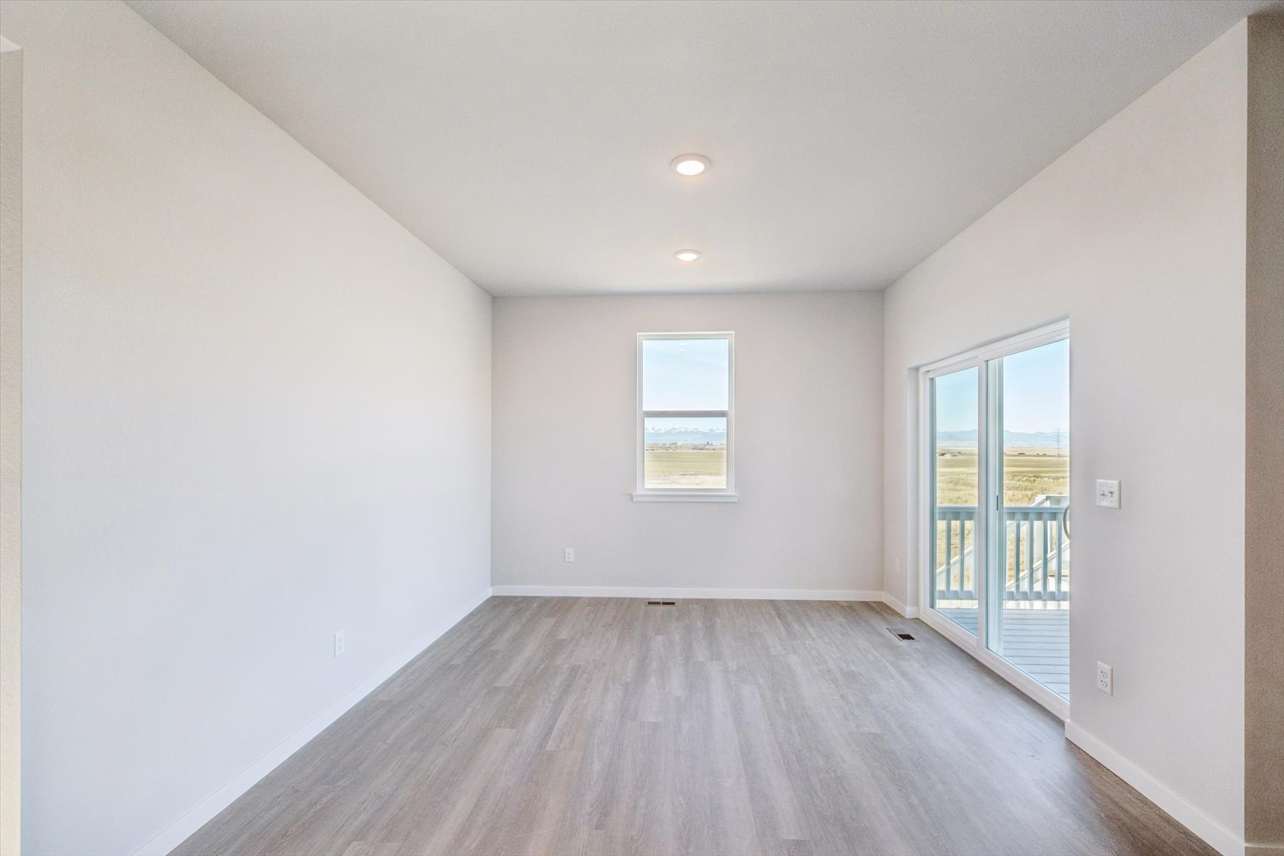 A room with a wood floor and a wood floor with a window.