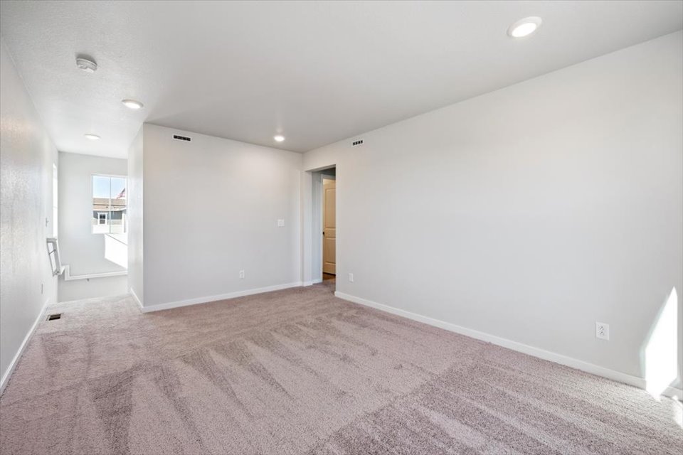 A room with a carpet and a door.