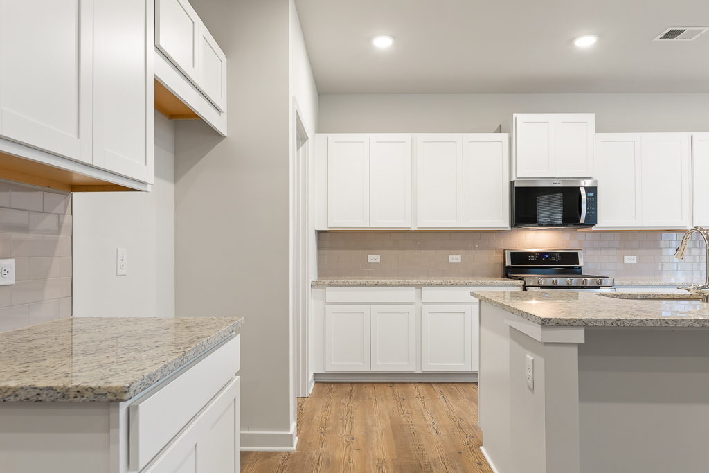A kitchen with white cabinets.