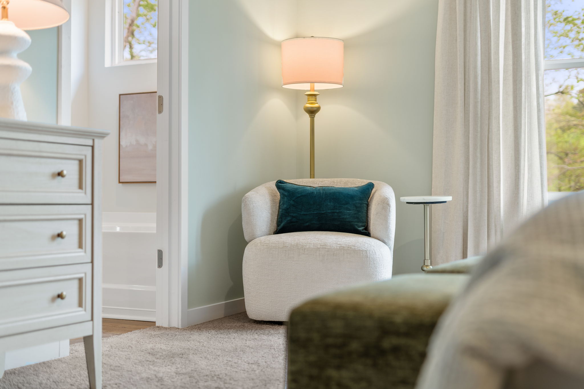 A room with a couch and a lamp.