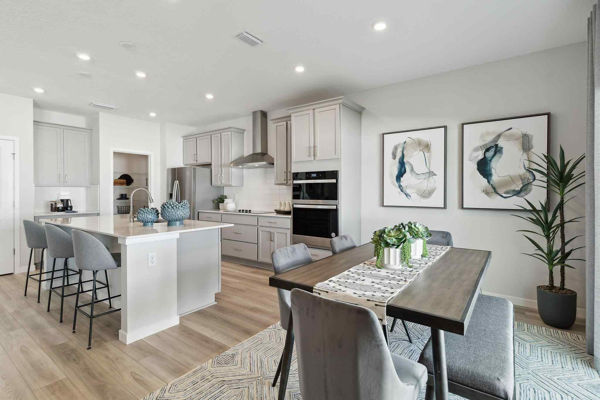 A kitchen with a dining table and chairs.