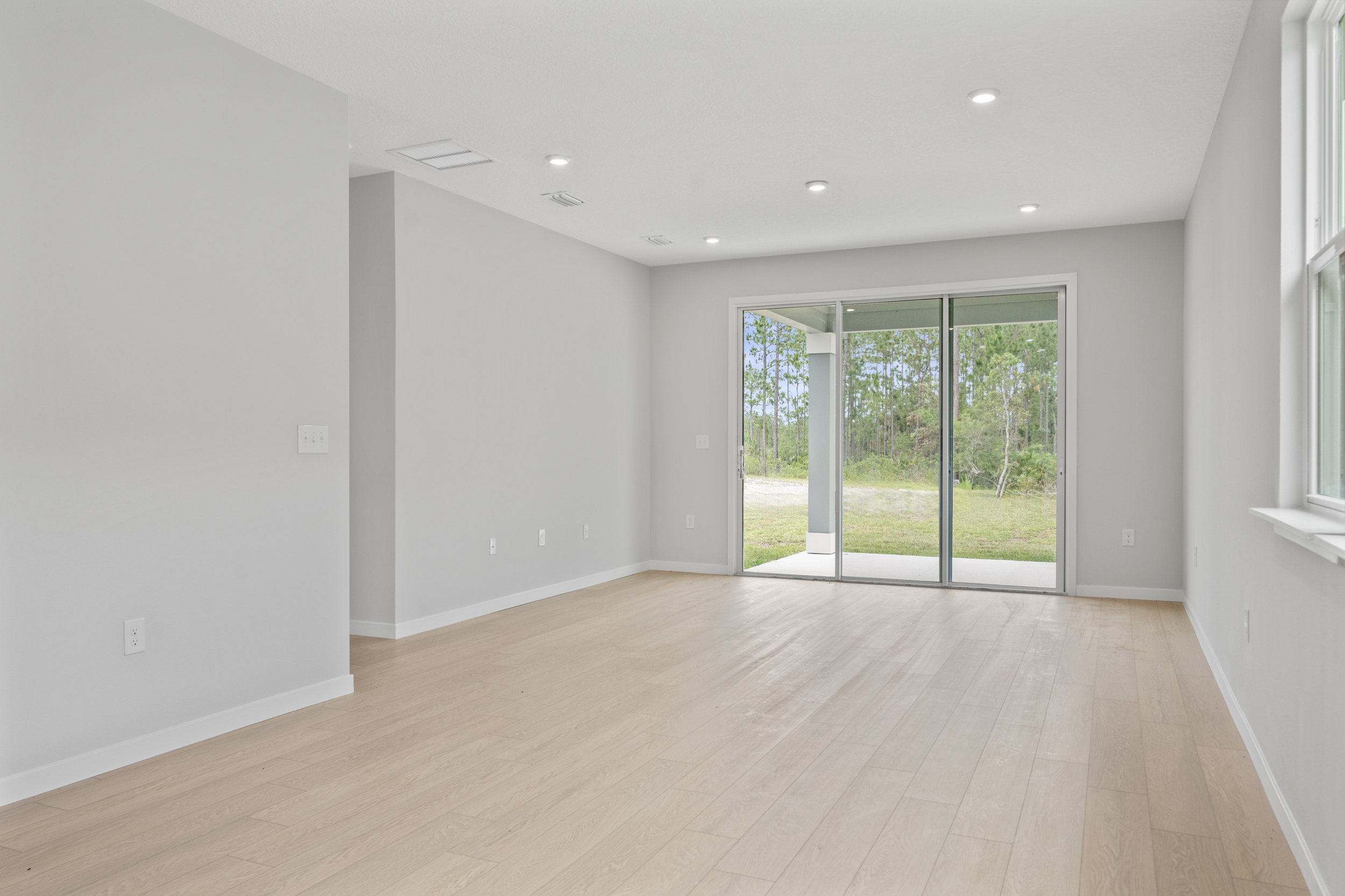 Sanibel II Floorplan Lot 72 Great Room with Triple Slider Patio Door at Seminole Palms in Palm Coast