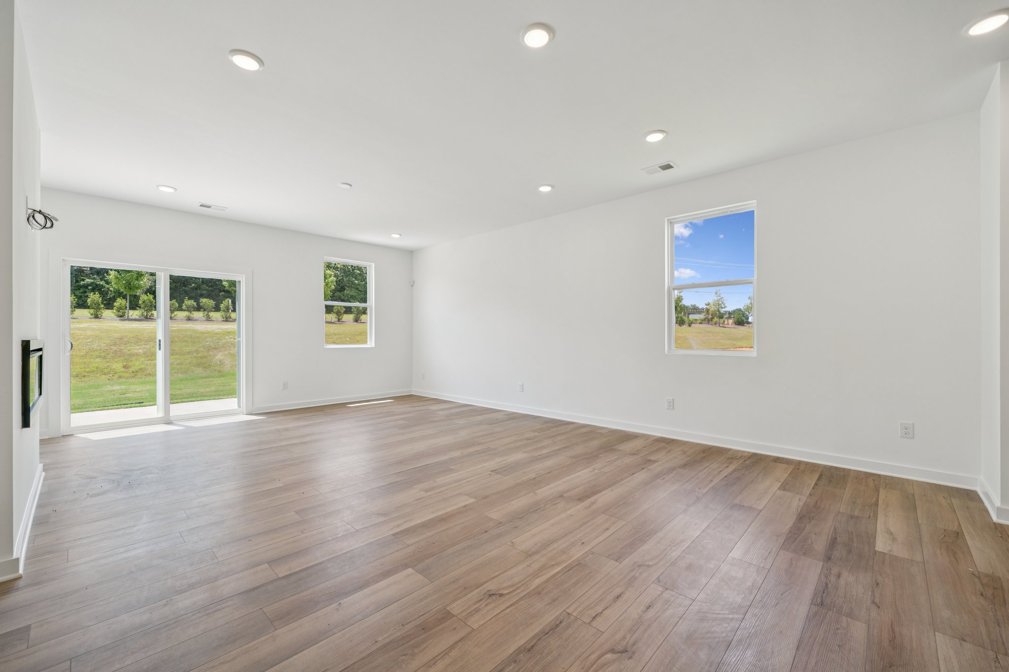 A room with a wood floor and a wood floor with a window.