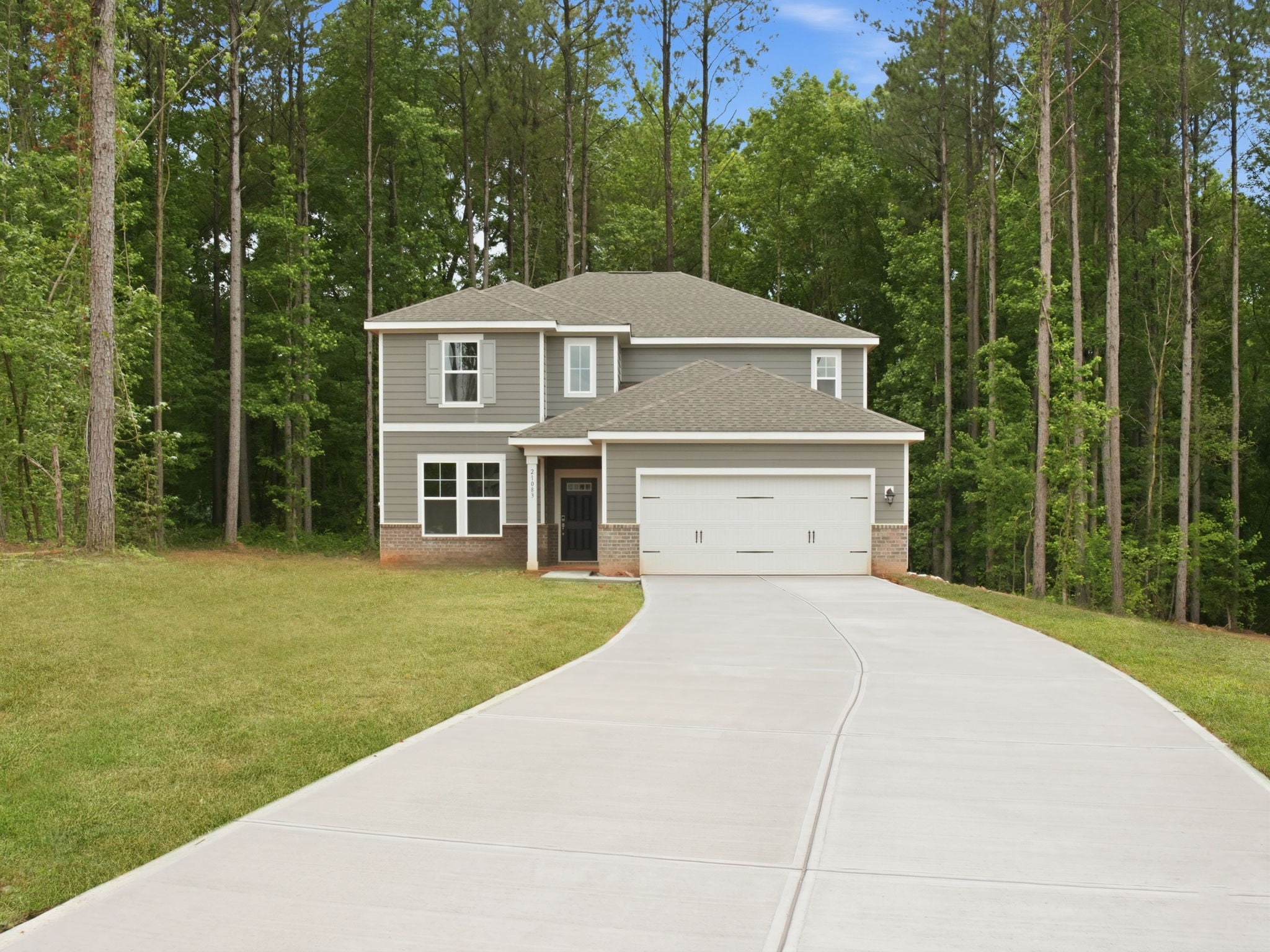 A house with a driveway and trees around it.