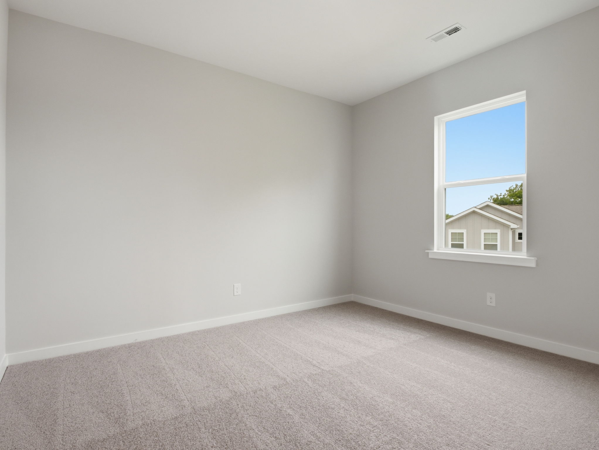 A room with a window and carpet.