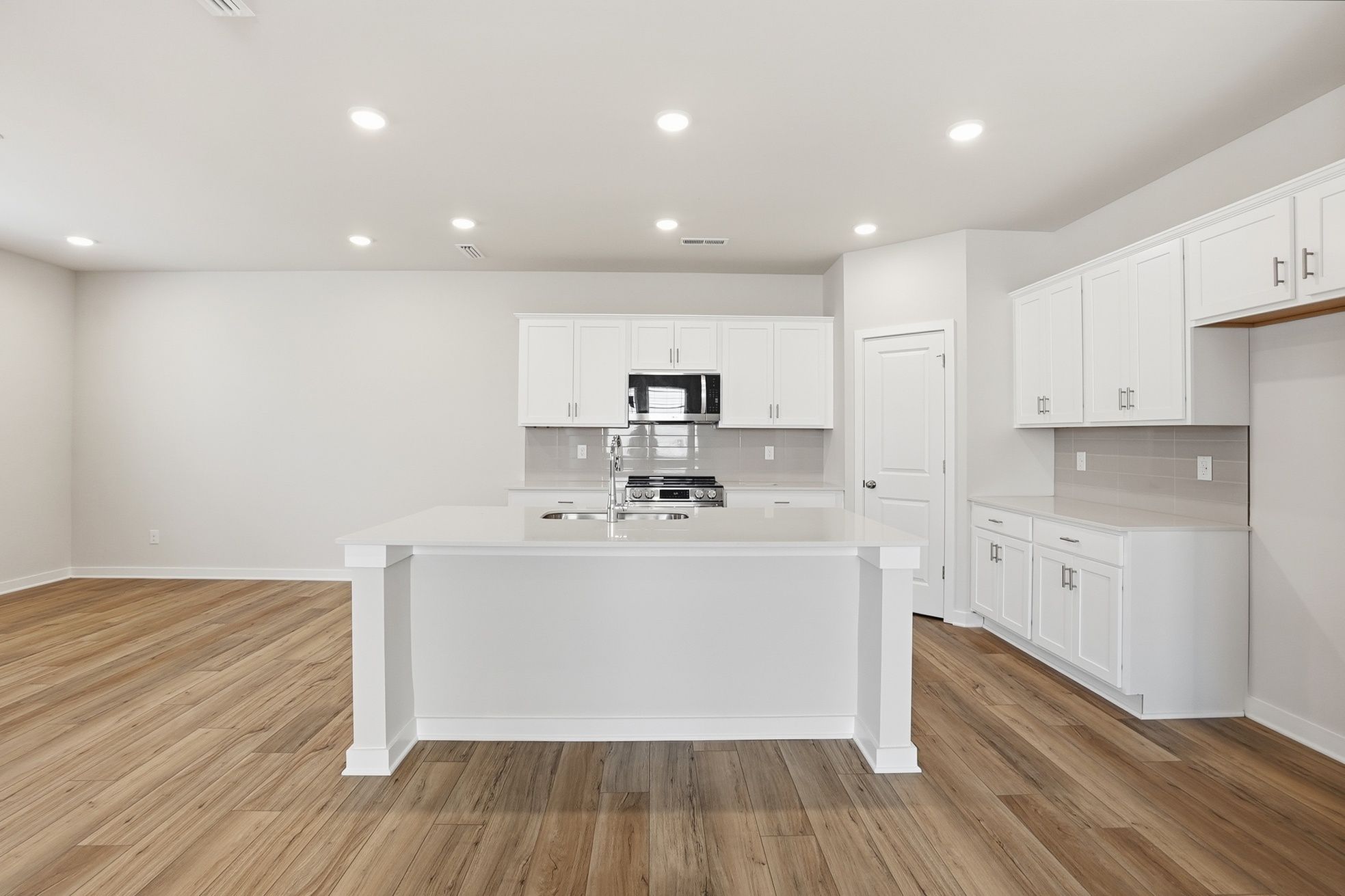 A kitchen with white cabinets.