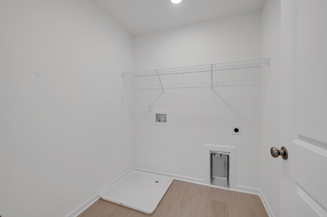 A white room with a wood floor and a white door.