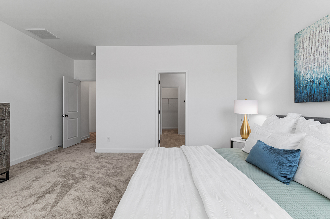 A bedroom with a bed and a lamp.