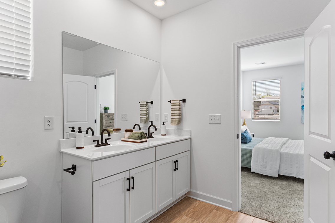 A bathroom with white cabinets.