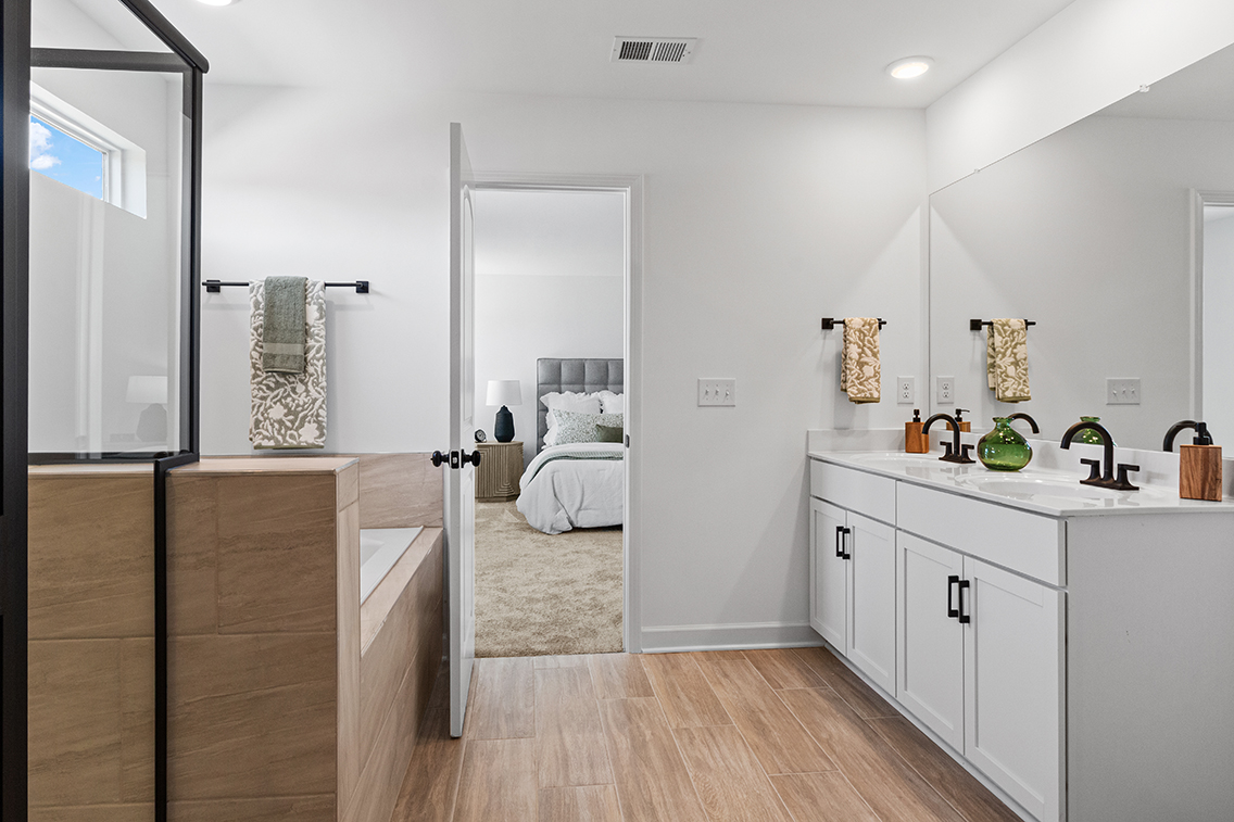 A bathroom with a bed and a mirror.