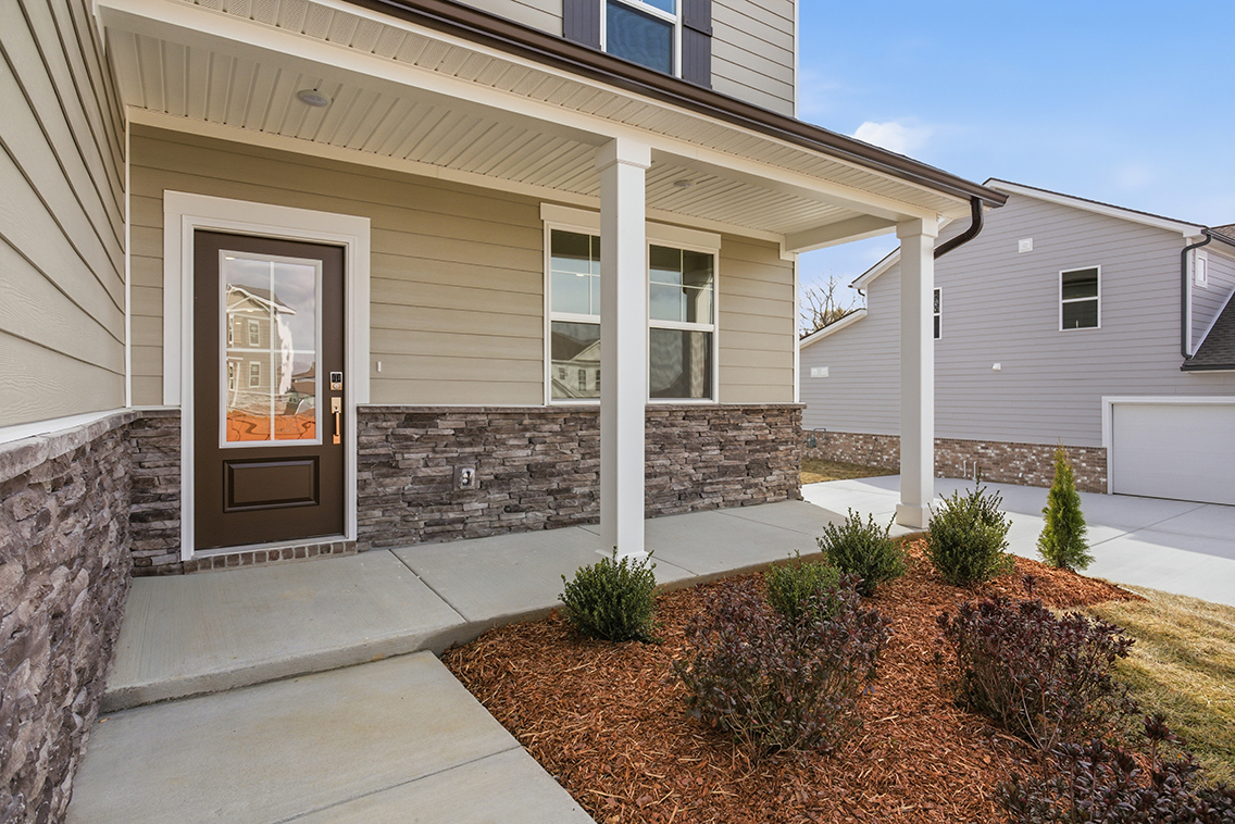 A house with a stone wall and a door.