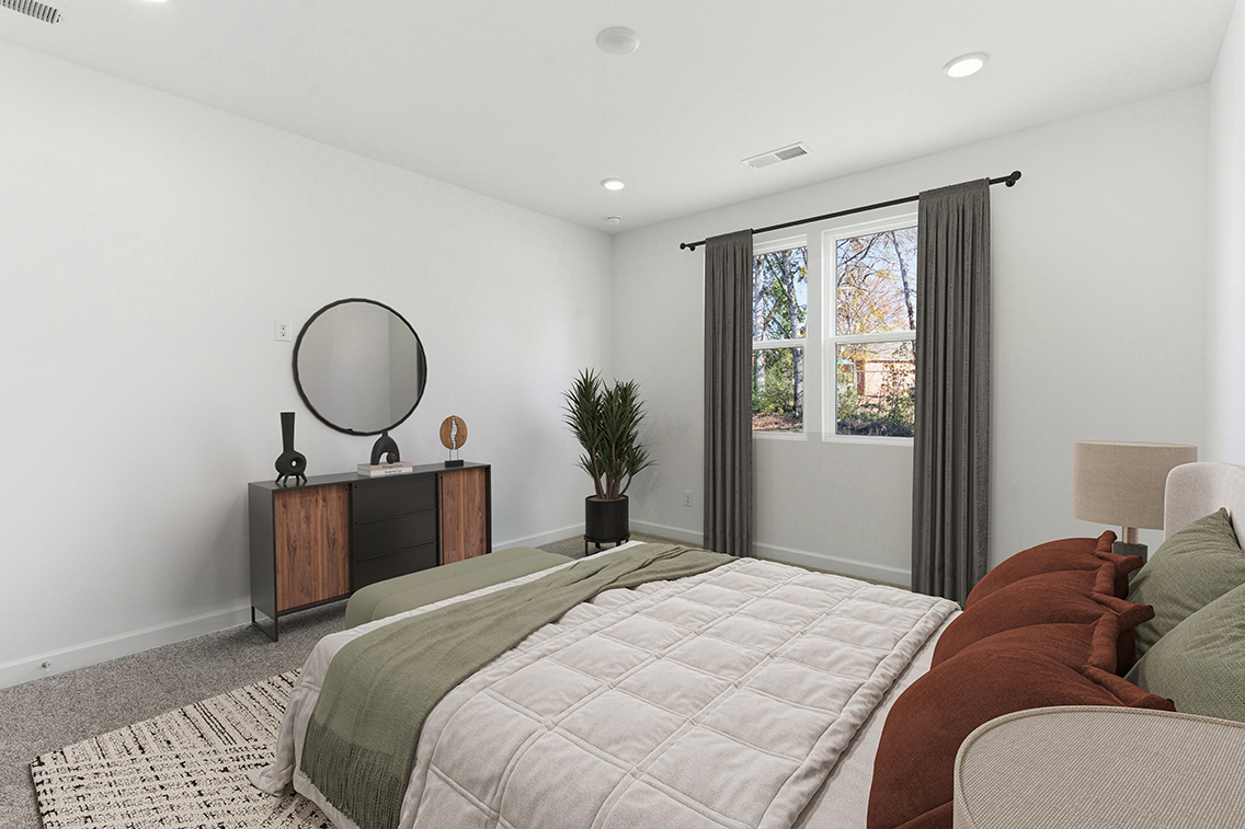 A bedroom with a bed and a mirror.