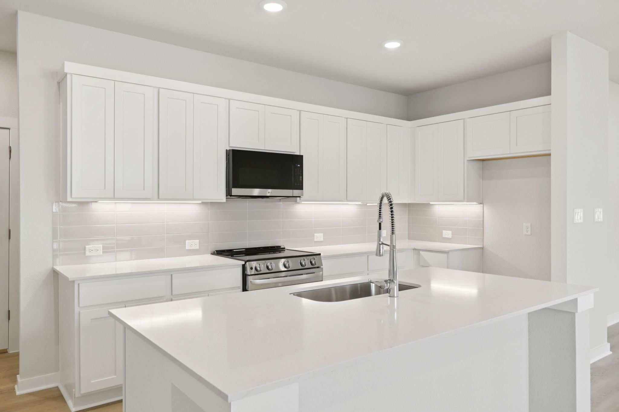 A kitchen with white cabinets.