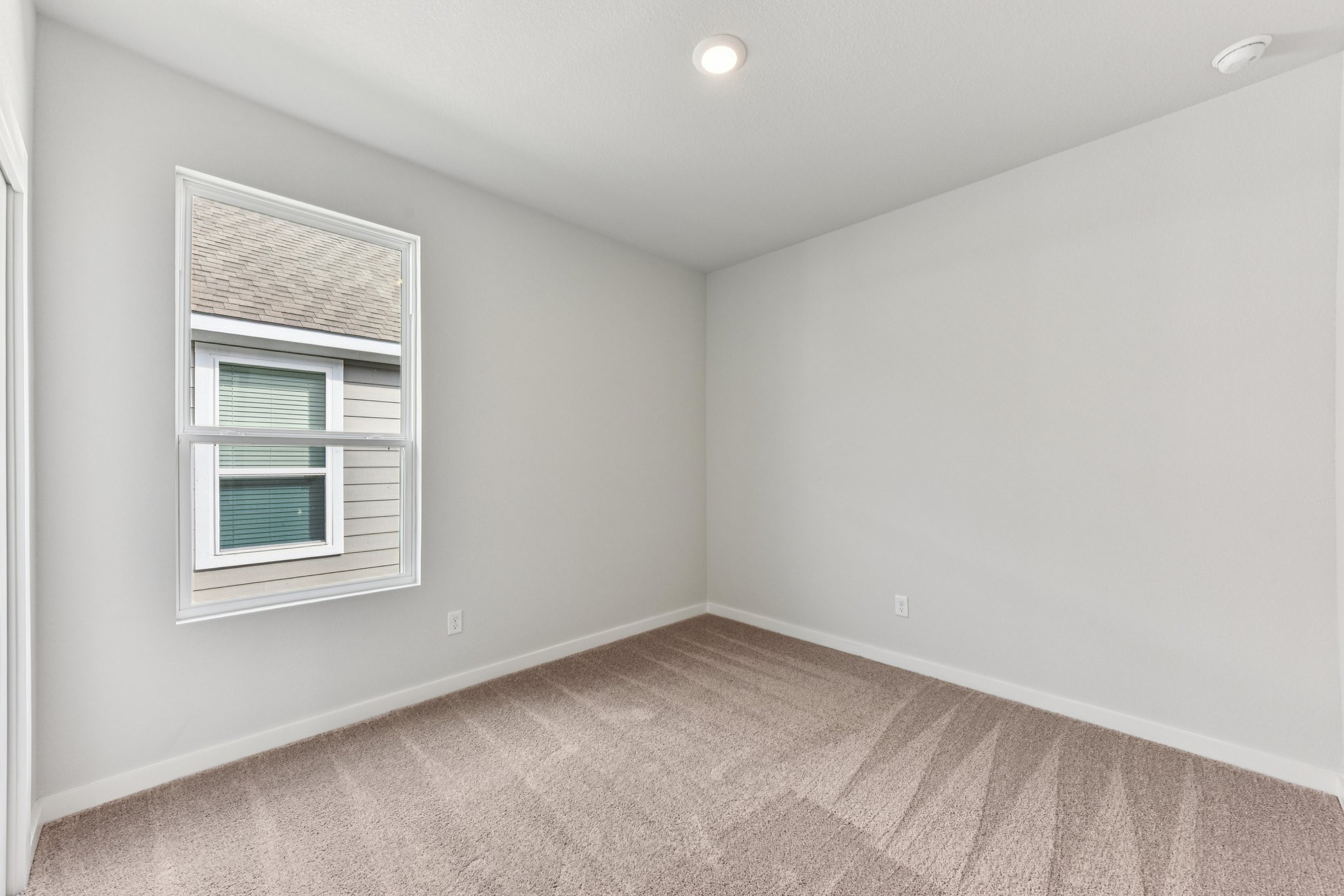 A room with a window and a carpet.