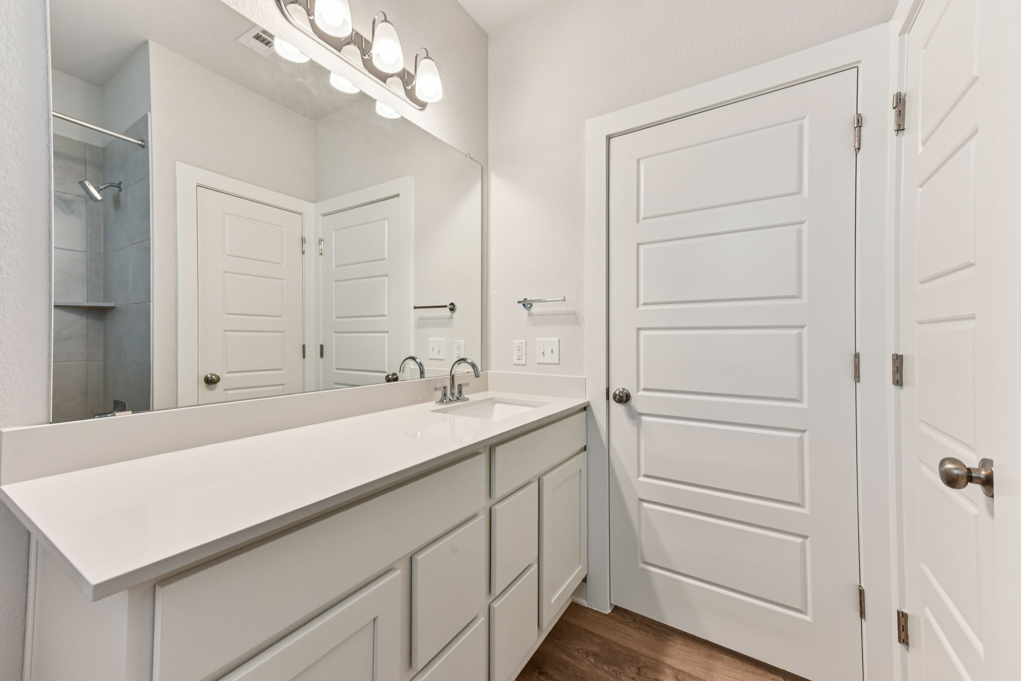A bathroom with white cabinets.