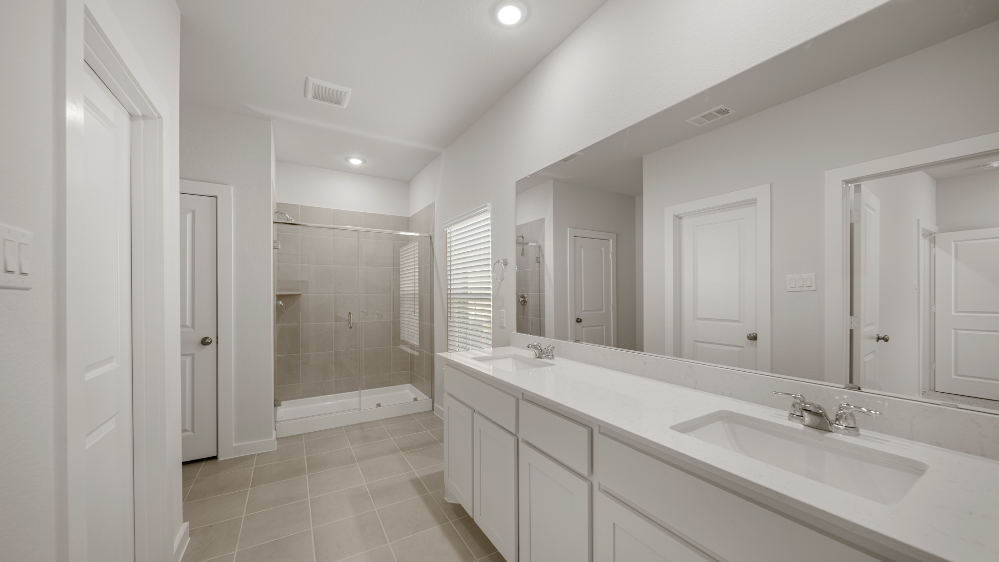 A bathroom with a sink and a shower unit.