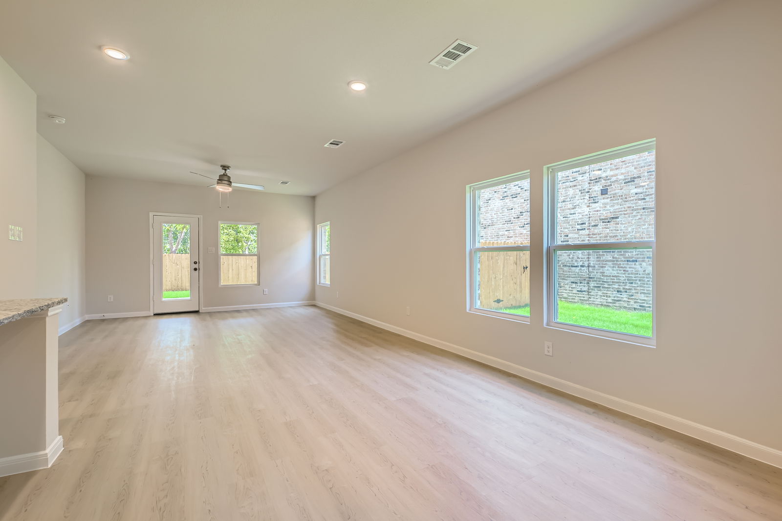 A room with a wood floor and windows.
