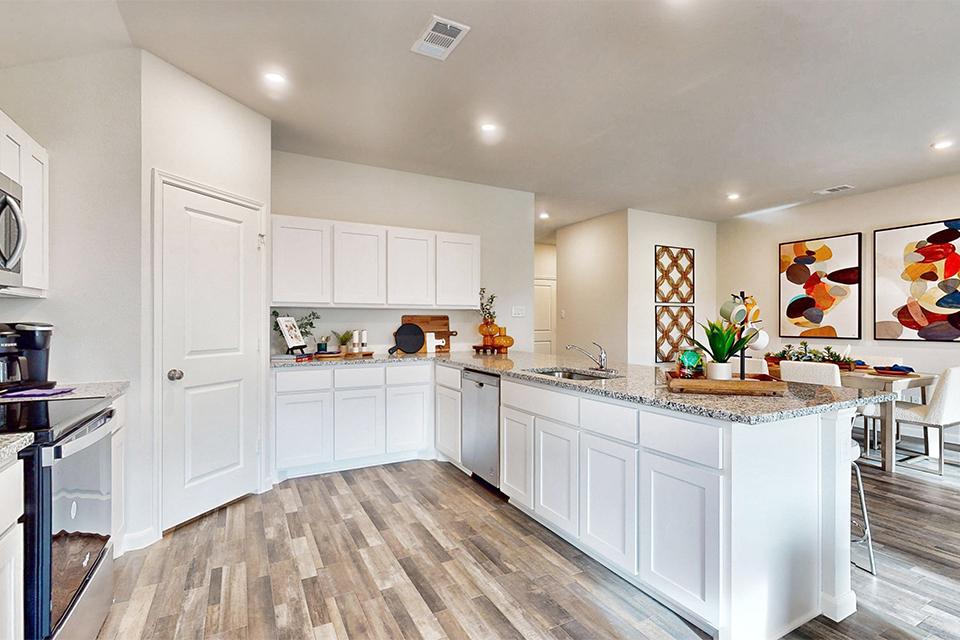 A kitchen with white cabinets.