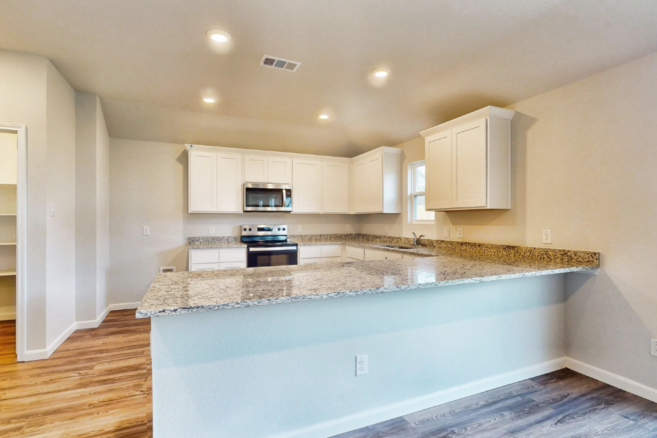 A kitchen with marble counters.