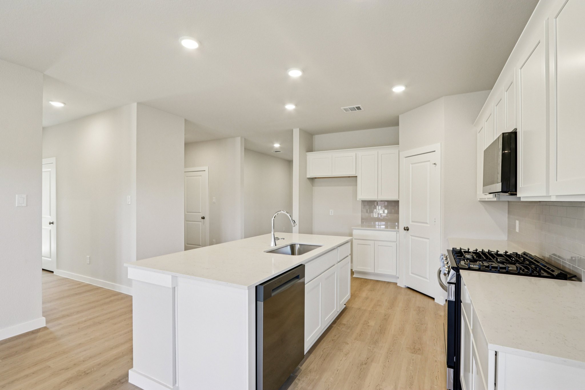 A kitchen with white cabinets.