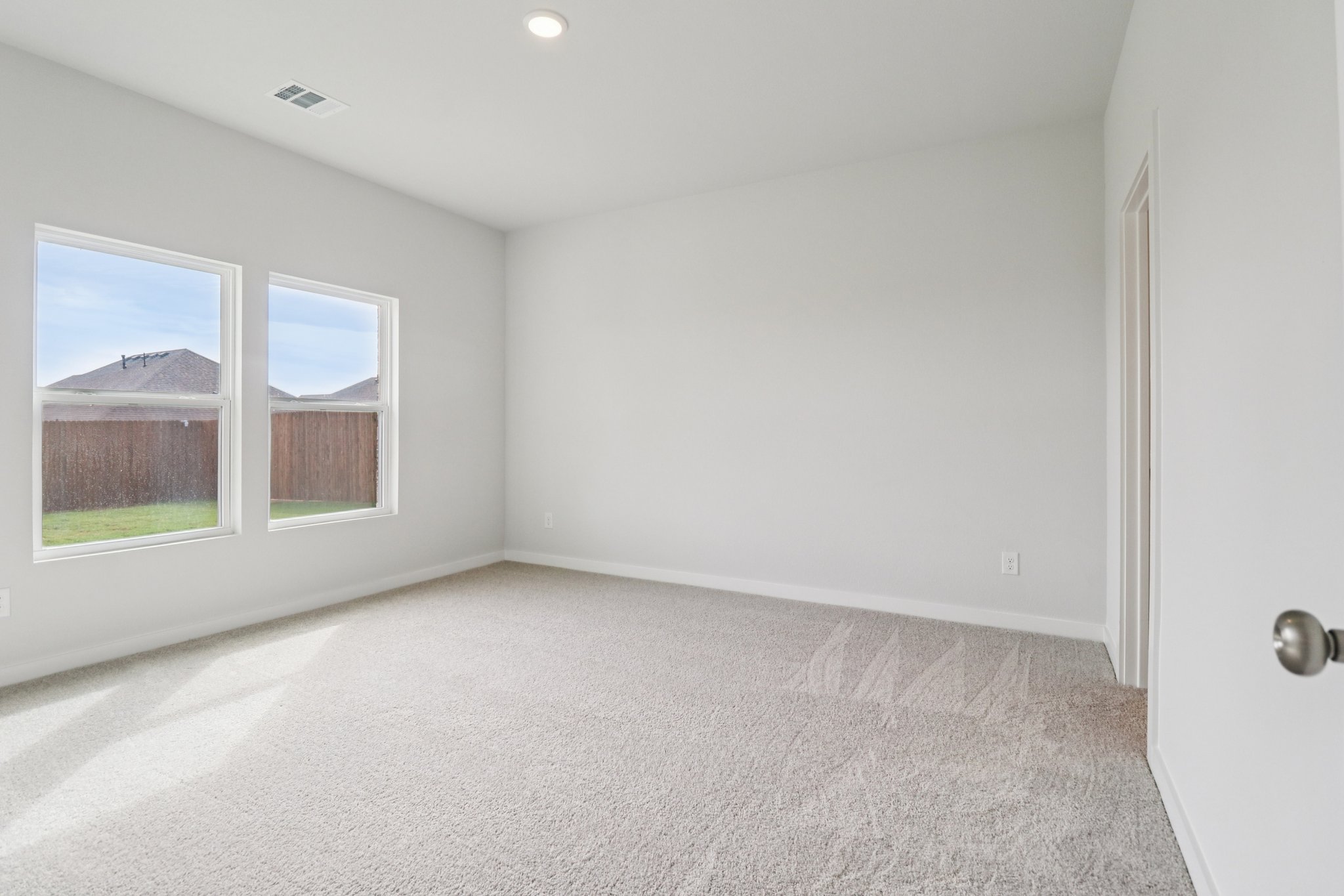 A room with a window and a carpet.