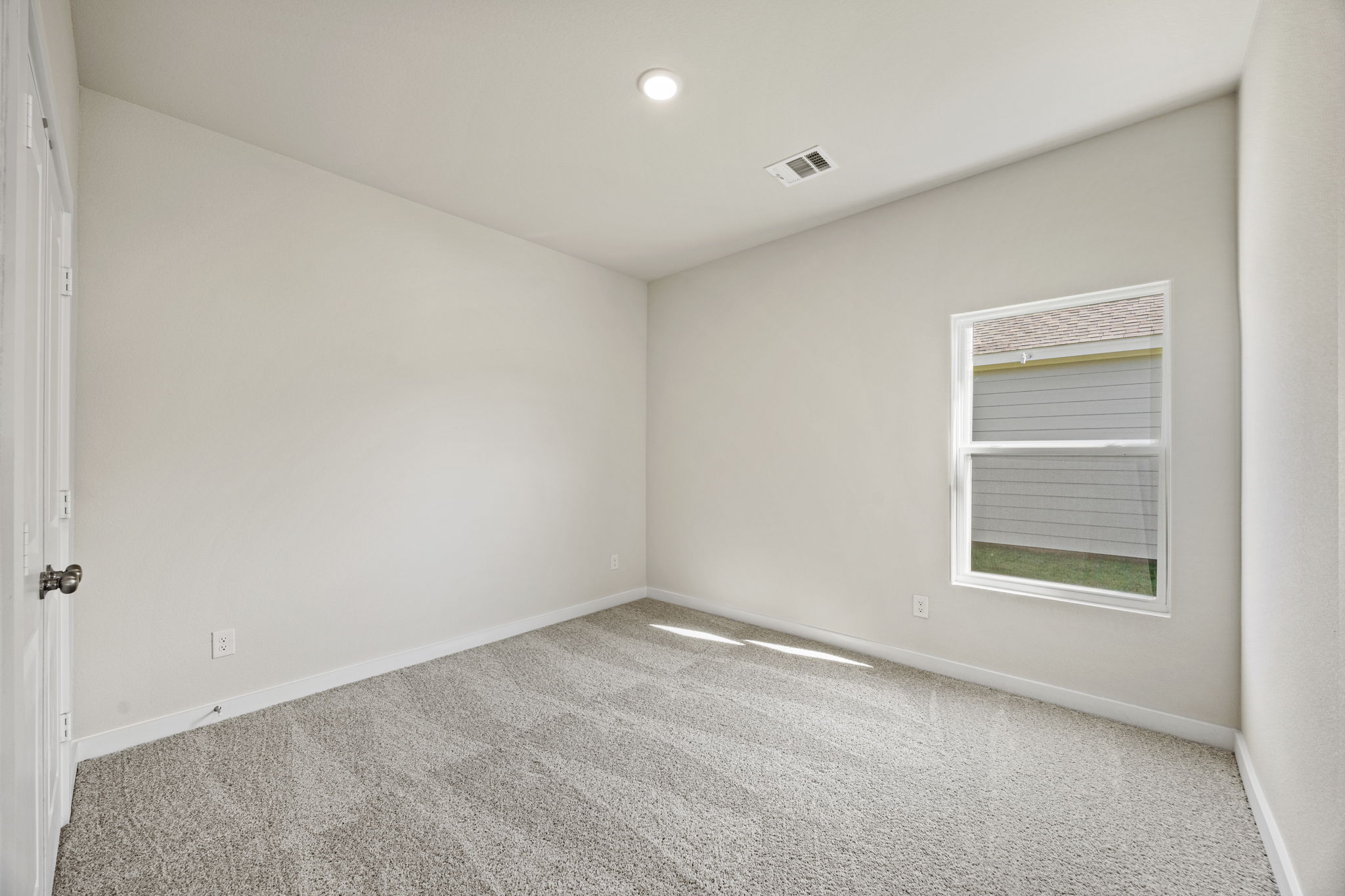 A room with a carpet and a window.