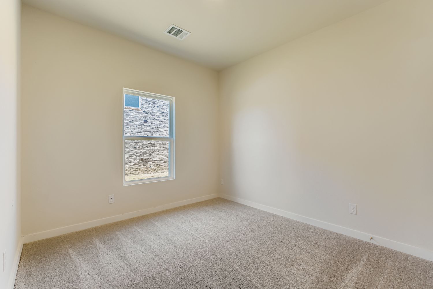 A room with a window and carpet.