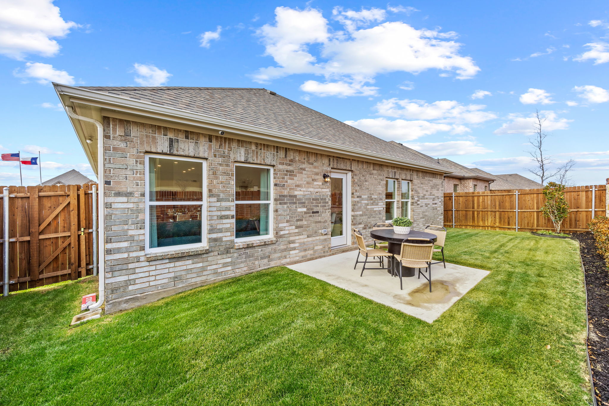 A house with a yard and a table and chairs.