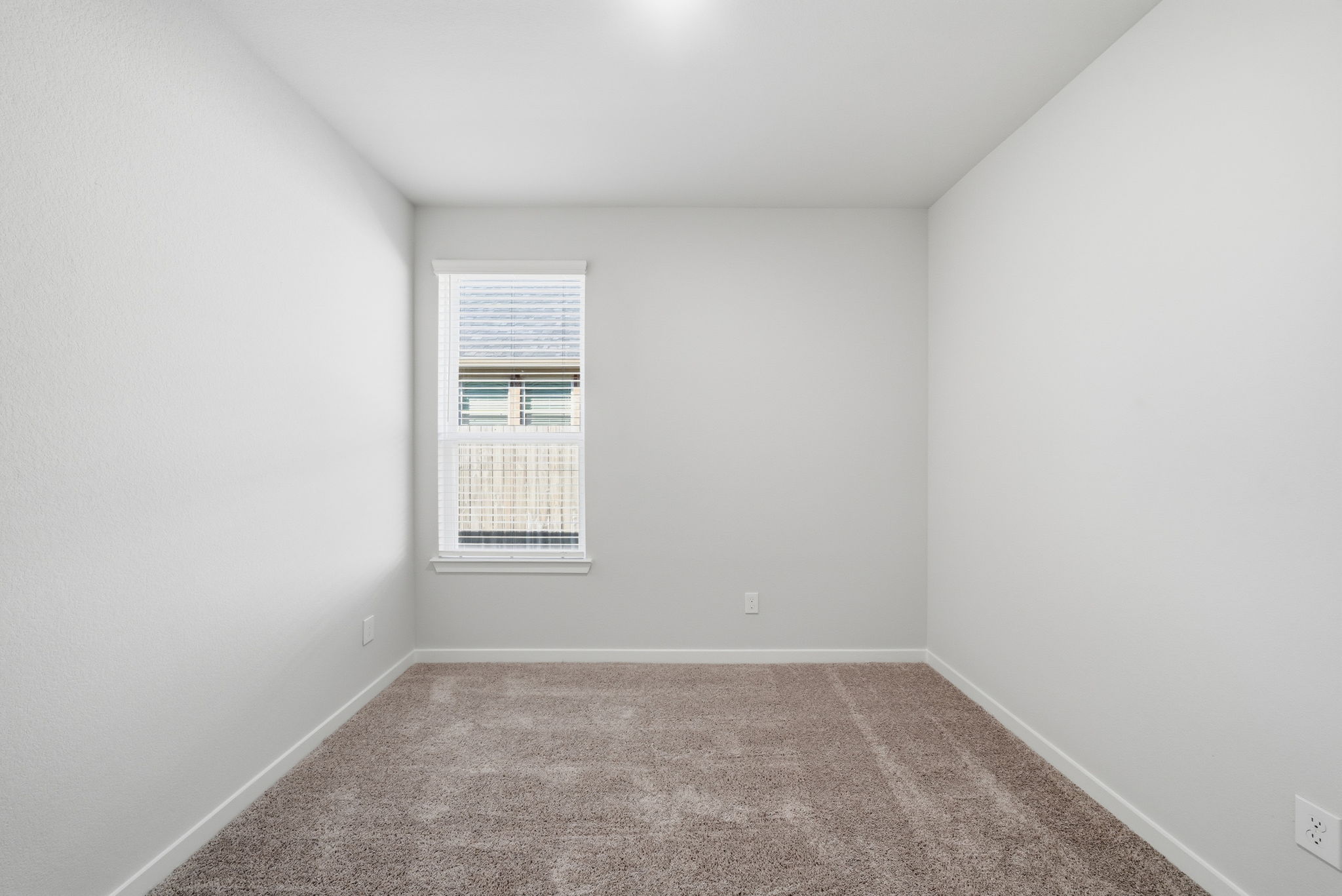 A room with a carpet and a window.