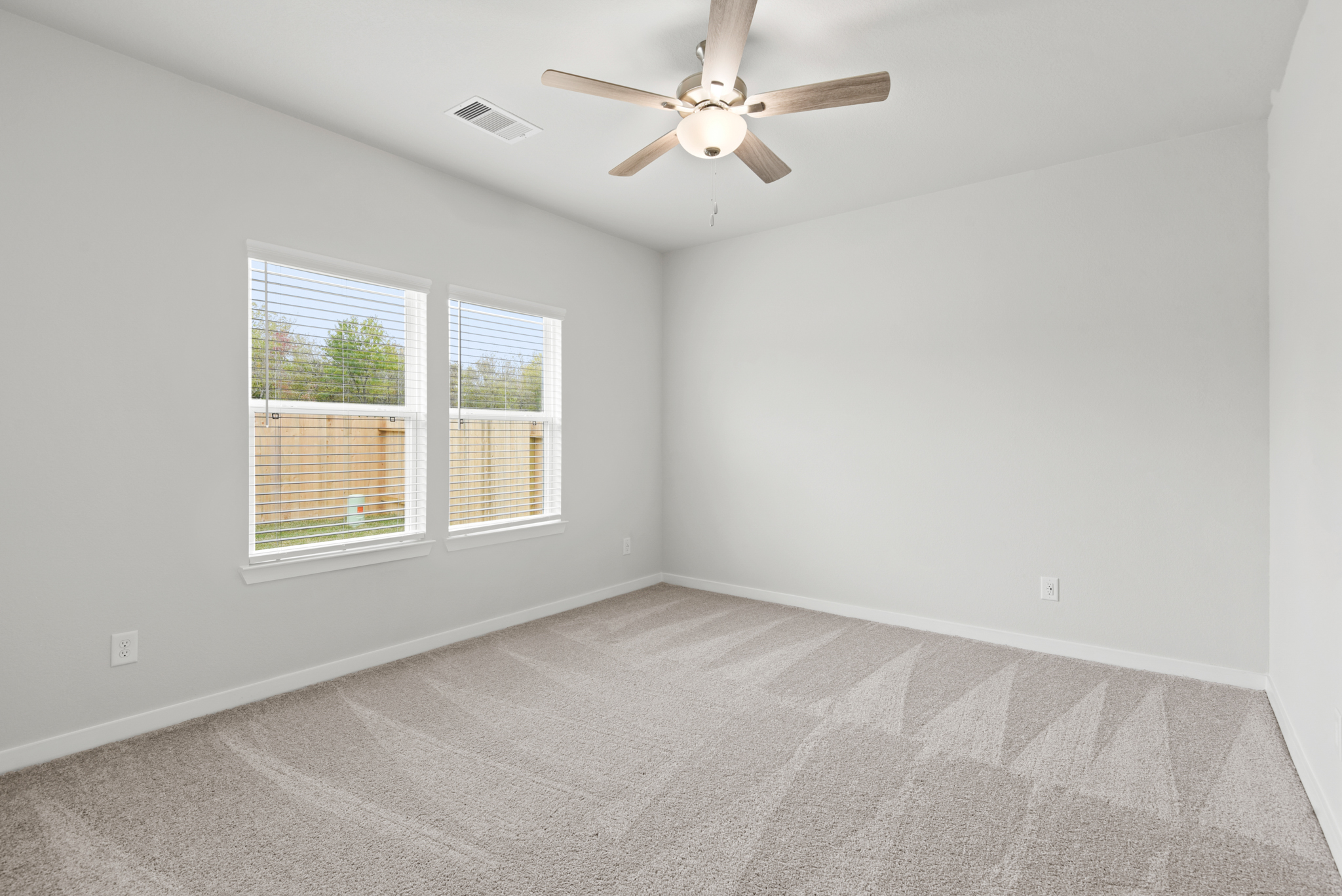 A room with a ceiling fan and a window.