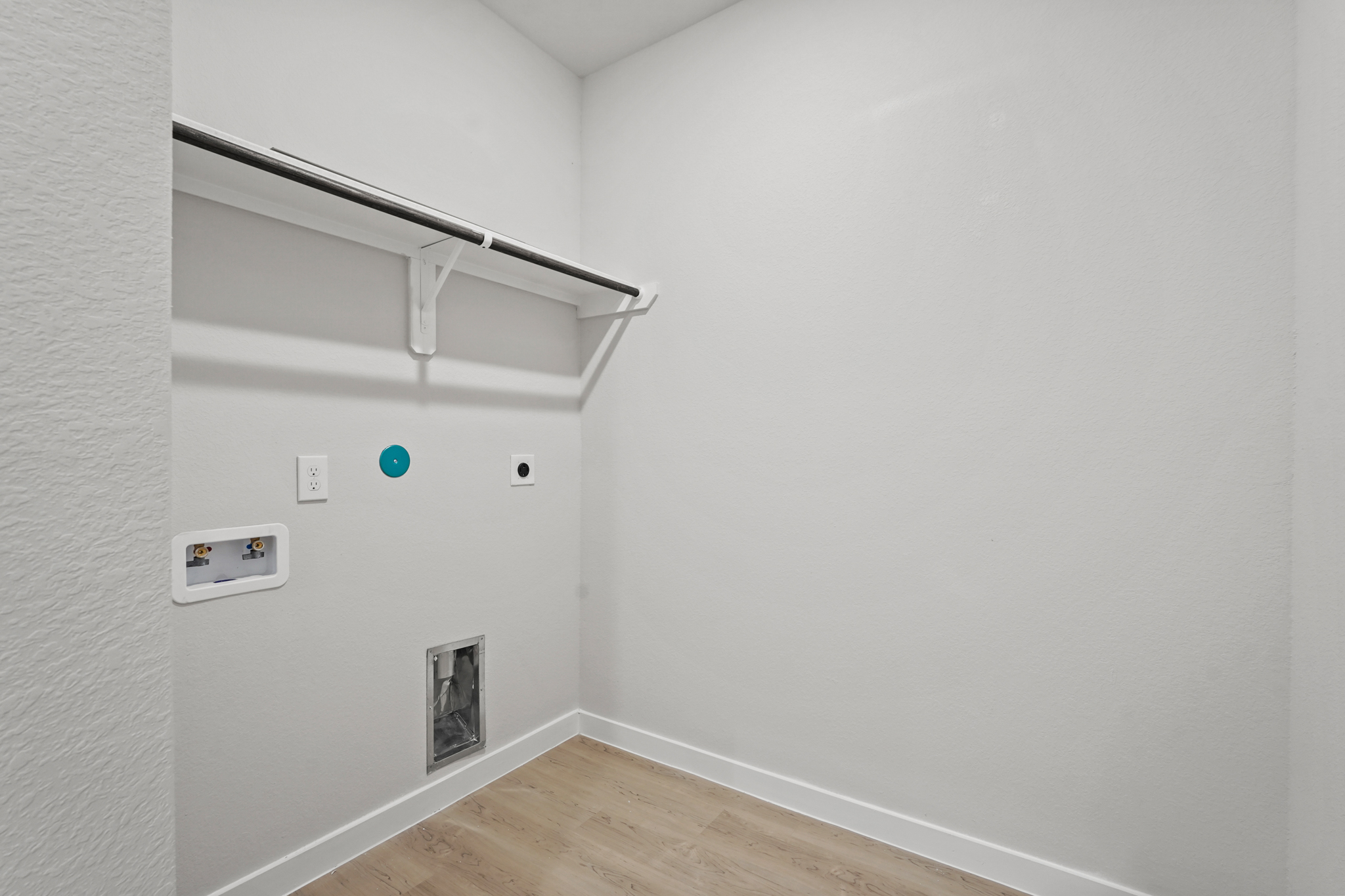 A white wall with a wood floor.