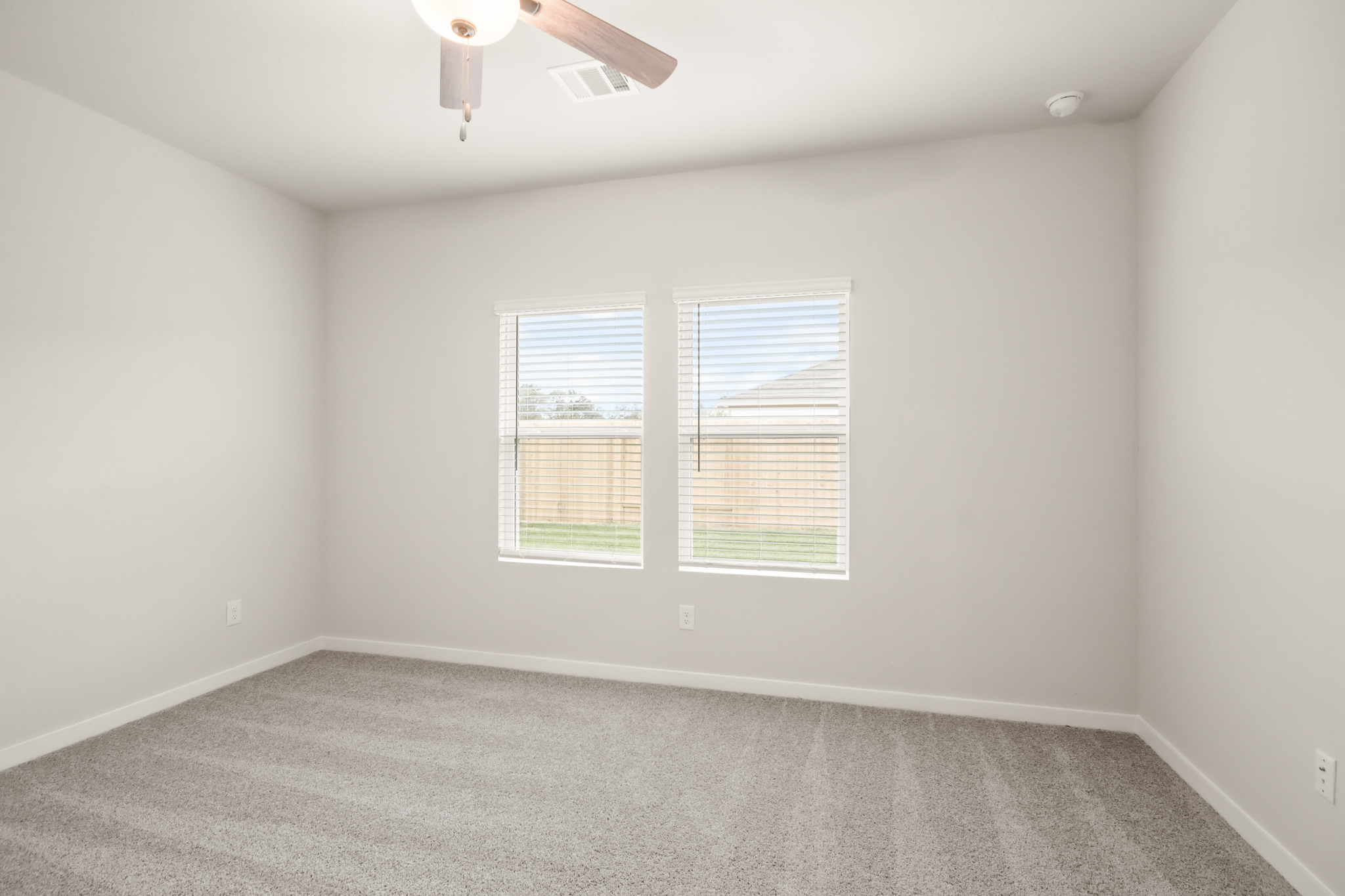 A room with a ceiling fan and a window.